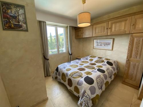 a bedroom with a bed with a patterned comforter at Apartment Le Domaine de la Baie-1 by Interhome in Cavalaire-sur-Mer