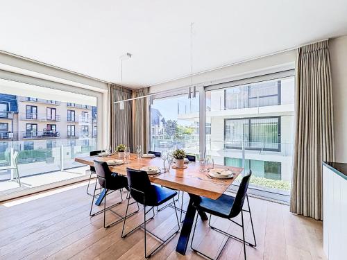 a dining room with a table and chairs and large windows at Apartment Wanderlust with garage by Interhome in Mispelburg