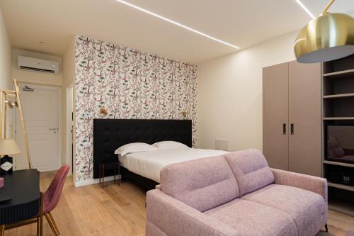 a bedroom with a bed and a couch at B&B Le Suite del Corso in Lugo