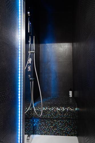 a shower with a hose in a black bathroom at B&B Le Suite del Corso in Lugo