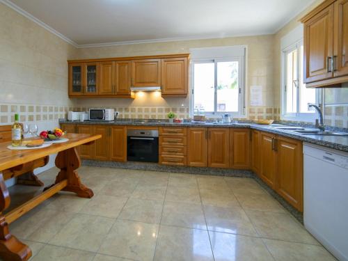 a large kitchen with wooden cabinets and a table at Villa Villa Delfín by Interhome in Calpe