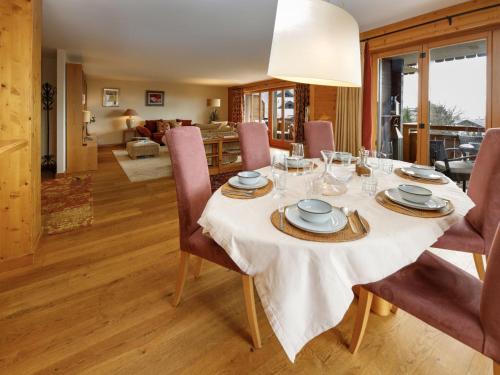 a dining room with a table and chairs and a living room at Apartment Pré Vert 3 by Interhome in Villars-sur-Ollon