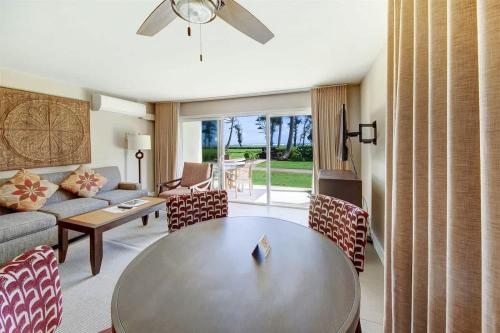 a living room with a table and a couch at Ocean View Condo Pono Kai Resort PF-G102 in Kapaa