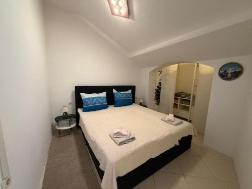 a bedroom with a bed with blue pillows and a mirror at Seafront Apartment Bakar in Bakar