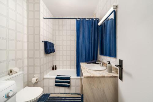 a bathroom with a tub and a sink and a toilet at Sunny Beach Praia da Rocha Sea Views Algarve in Portimão
