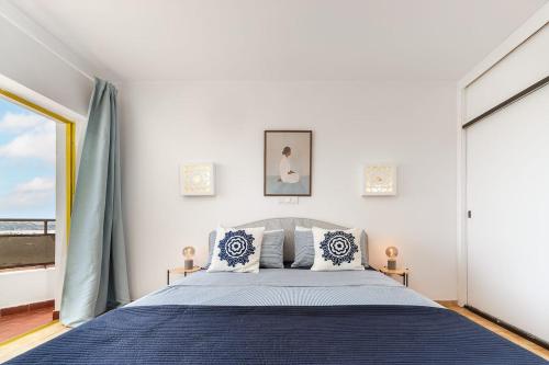a bedroom with a bed and a large window at Sunny Beach Praia da Rocha Sea Views Algarve in Portimão