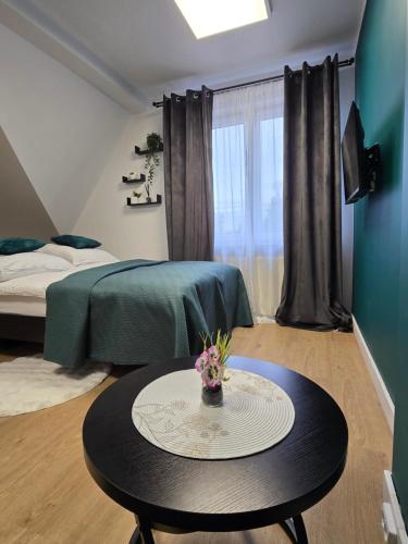 a small room with a table and a bed and a bed at Apartamenty Nad Suwalskim Bulwarem in Suwałki