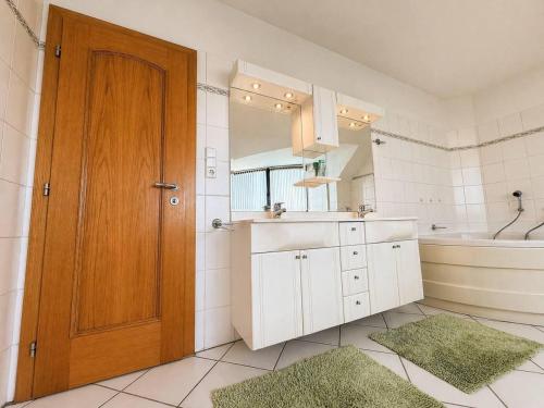 a bathroom with a sink and a mirror and a door at Villa Grande Praha in Prague