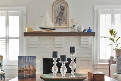 a living room with a fireplace and a table with two wine glasses at Rivercrest Bungalow Retreat in Tampa