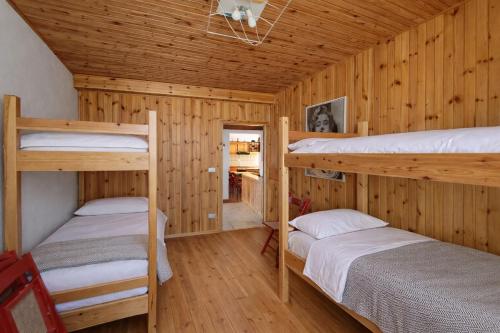 a bedroom with two bunk beds in a cabin at Appartamento Alta Valle Maira - Nebin in Villaro