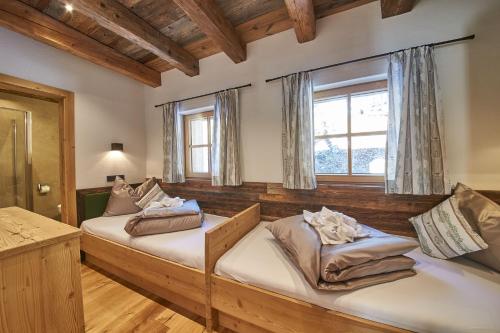 two beds in a room with a window at Almhütte Lengau in Saalbach-Hinterglemm