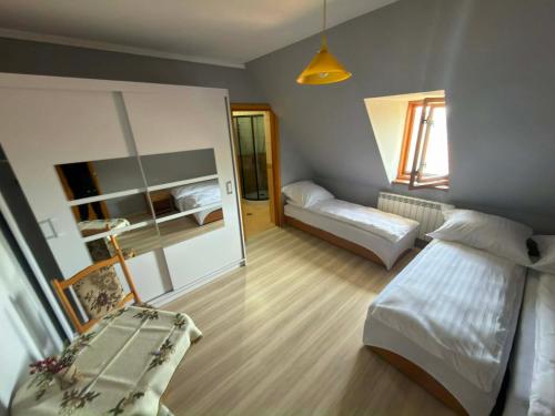 a small bedroom with two beds and a mirror at Domek Przy Potoku in Biały Dunajec
