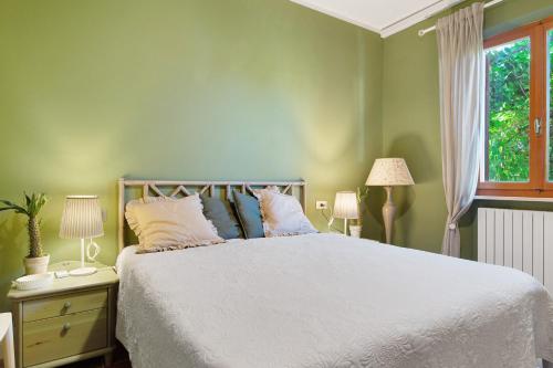 a bedroom with a white bed and a window at Pino Vallegrande in Procchio