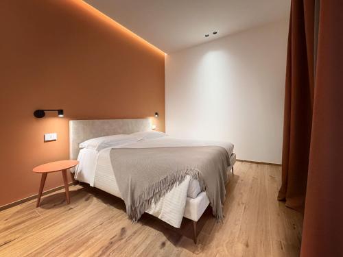 a bedroom with a large bed and a table at BOREMA Apulian Rooms in Andria
