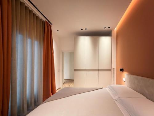 a bedroom with a white bed and a window at BOREMA Apulian Rooms in Andria
