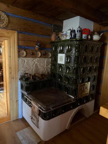 a kitchen with an old stove in a room at Goralska Chalupa in Vígľaš