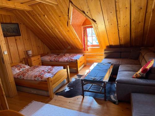 a room with two beds and a couch in a cabin at Goralska Chalupa in Vígľaš