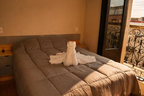 a stuffed animal sitting on top of a bed at El Suburbio - Serapio Rendon in Morelia