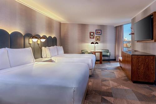 a hotel room with two beds and a flat screen tv at The Royal Sonesta Boston in Cambridge