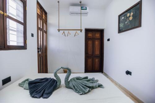 a room with two swans sitting on a bed at Nyumbani Stonetown in Zanzibar City