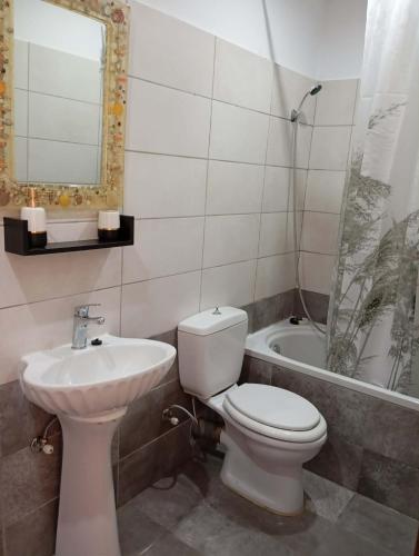 a bathroom with a toilet and a sink and a tub at Casa di Nonno in Alikanas