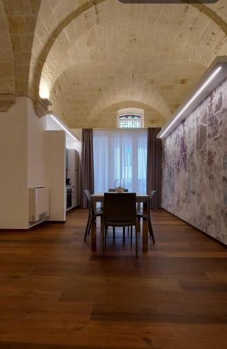 a dining room with a table and a kitchen at Dimora Andrè - Monopoli Centro in Monopoli