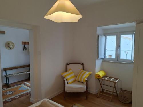 a room with a chair and a pendant light at Casa D Alma in Aljustrel