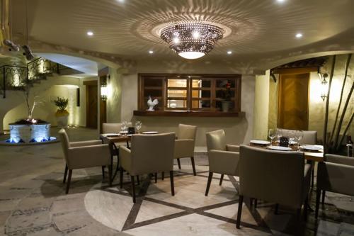 a dining room with tables and chairs and a chandelier at Hotel Lindo Ajijic Bed & Breakfast in Ajijic