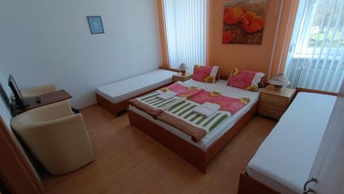 a small bedroom with two beds and a chair at Pension Motel Anna in Lenora