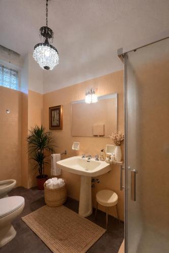 a bathroom with a sink and a toilet and a mirror at Shared rooms BOC in Brunate