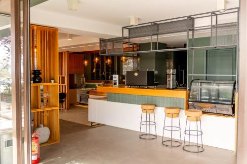 a kitchen with a counter with stools at Vila Victor Mizuumi in Mamaia