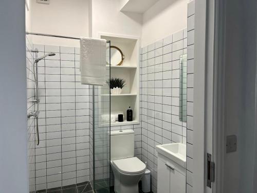 a white bathroom with a toilet and a sink at The Old Parish Office! in Midleton