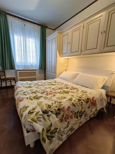 a bedroom with a large bed with a floral bedspread at Appartamento Storico a Palmanova in Palmanova
