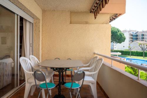 a table and chairs on a balcony with a pool at AT070 Piscina, 4 habitaciones, a 180m de la playa in Torredembarra