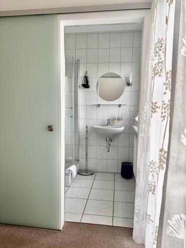 a white bathroom with a sink and a shower at Gästehaus Helbighof in Neustadt an der Weinstraße
