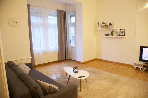 a living room with a couch and a tv at Five Season's Apartment in Budapest
