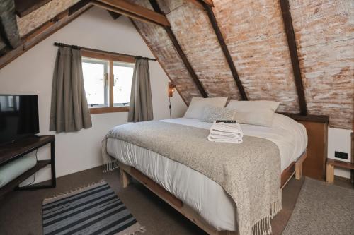 Ein Schlafzimmer mit Bett, Fernseher und einer Backsteinwand in der Unterkunft Casa Vigas, Ex-Rustika Hotel in Viña del Mar