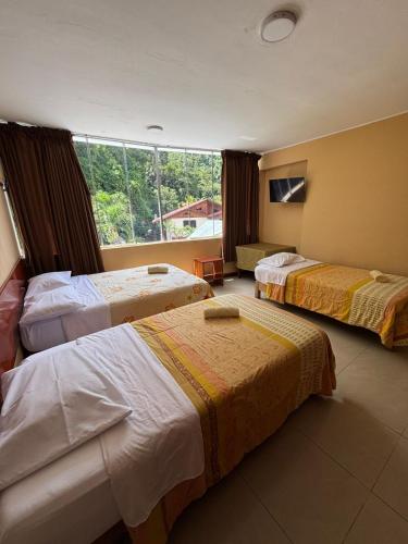 a hotel room with three beds and a window at Cerro Verde in San Ramón