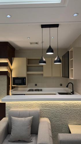 a living room with a couch and a kitchen at شاليهات الحدبان - Al Hadban Chalets in Ash Shafa