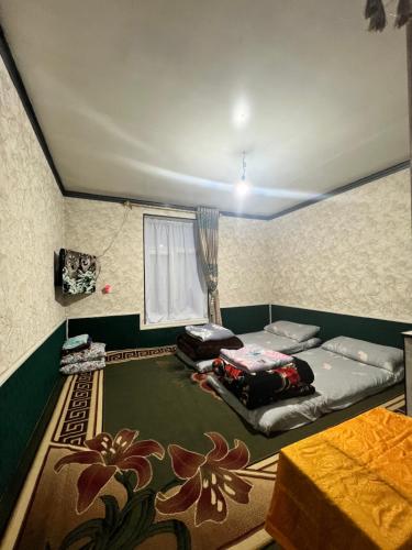 a room with a bed and a table in it at Shahzod Guesthouse & Homestay in Gelen