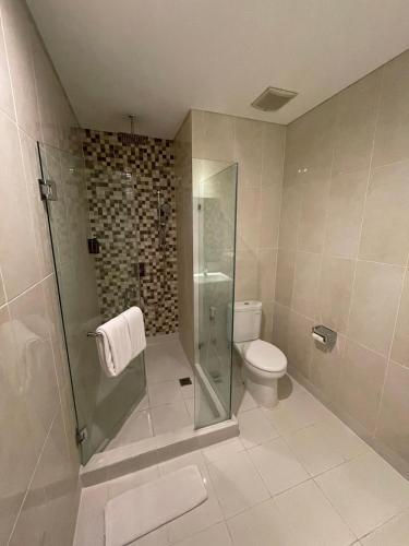a bathroom with a glass shower and a toilet at PrimeBiz Tegal in Tegal