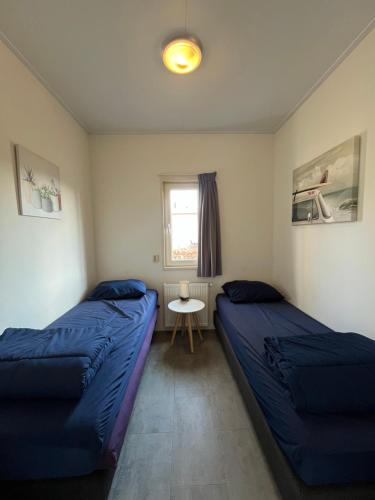 a bedroom with two beds and a table and a window at Lakeside Retreat at Veluwe in Nunspeet