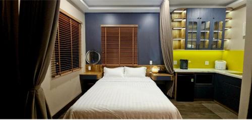 a small bedroom with a bed and a kitchen at Palisade Garden in Ấp Thiện Sơn