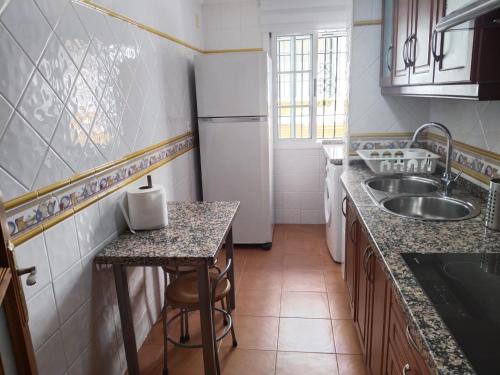 a small kitchen with a sink and a refrigerator at Piso Calatrava in Chipiona