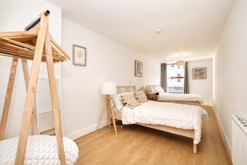two beds in a room with white walls and wooden floors at The MCR Prime Pad in Manchester
