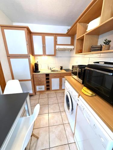 a kitchen with a washer and a dishwasher at Studio cosy les Sables d'Or in La Guérinière