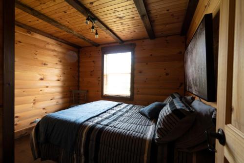 a bedroom with a bed in a log cabin at Chalet Le RV 3 in Notre-Dame-Des-Bois