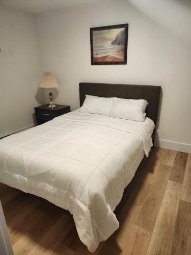 a bedroom with a bed with a white comforter at Serene Luxury Suite in Riverview
