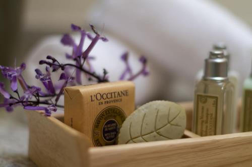 a wooden holder with a bottle of soap and purple flowers at Hotel Lindo Ajijic Bed & Breakfast in Ajijic