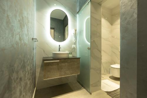 a bathroom with a sink and a mirror at Hotel Vila e Arte City Center in Tirana